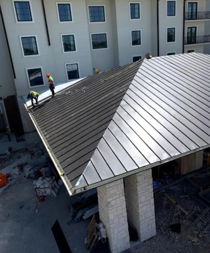 Crew installing standing seam metal roof panels on a commercial project in Rancho Santa Margarita